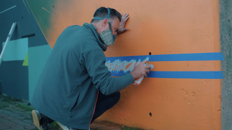 Artiste Remi Rough travaillant sur une muraille à Halifax.